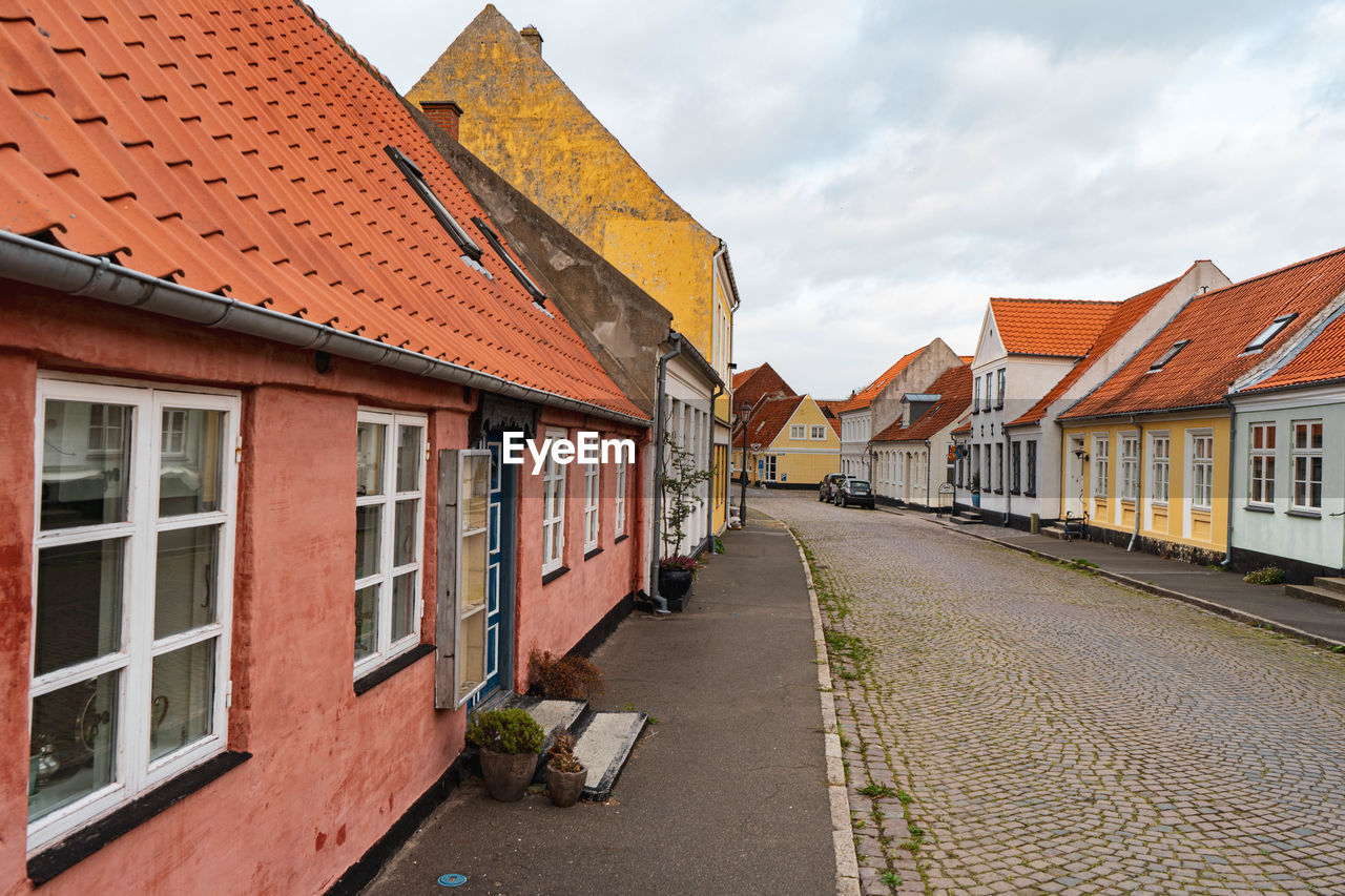 Street amidst buildings in town against sky