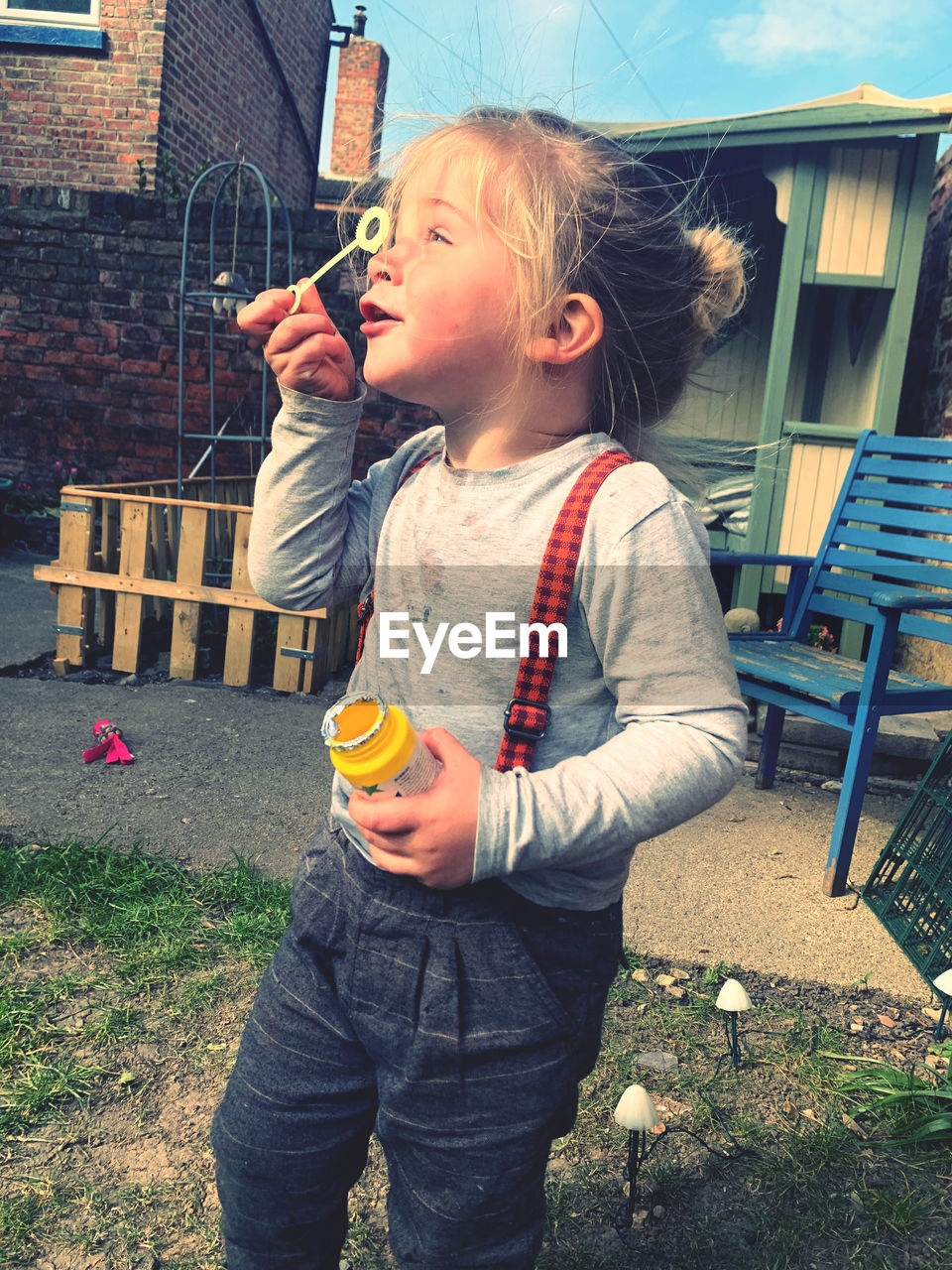 CUTE BOY STANDING AT YARD