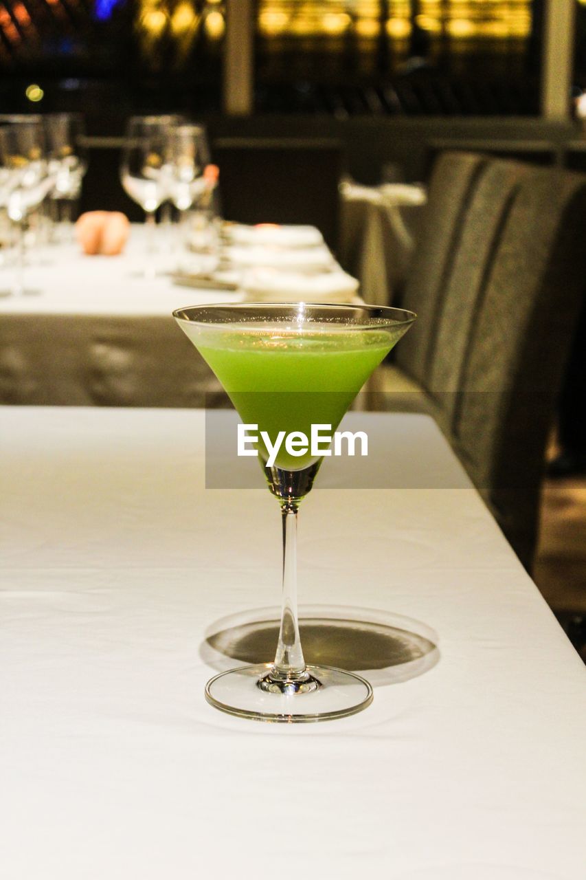 Close-up of drink in martini glass on table at restaurant