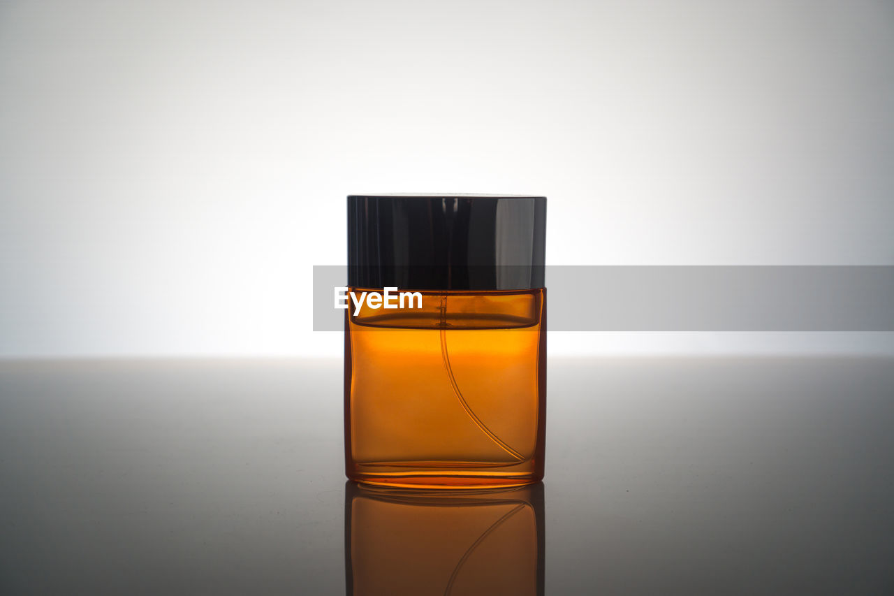 Close-up of perfume on table against gray background