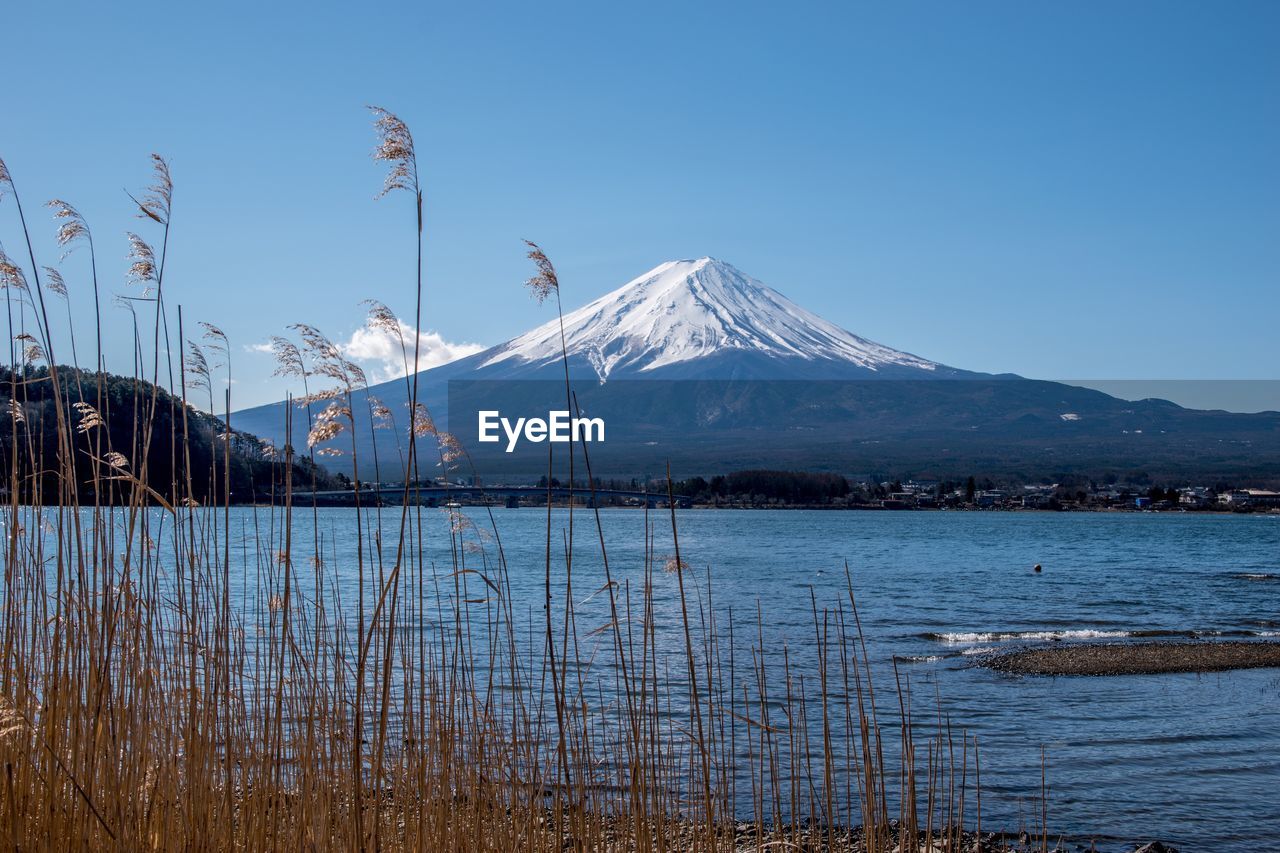 Scenic view of snowcapped mountains against clear blue sky