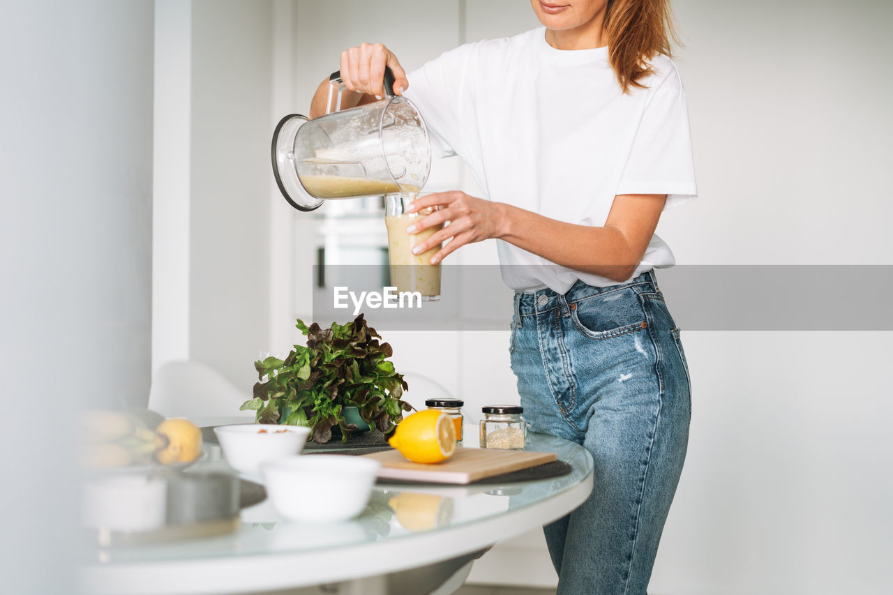 midsection of woman holding water from bottle