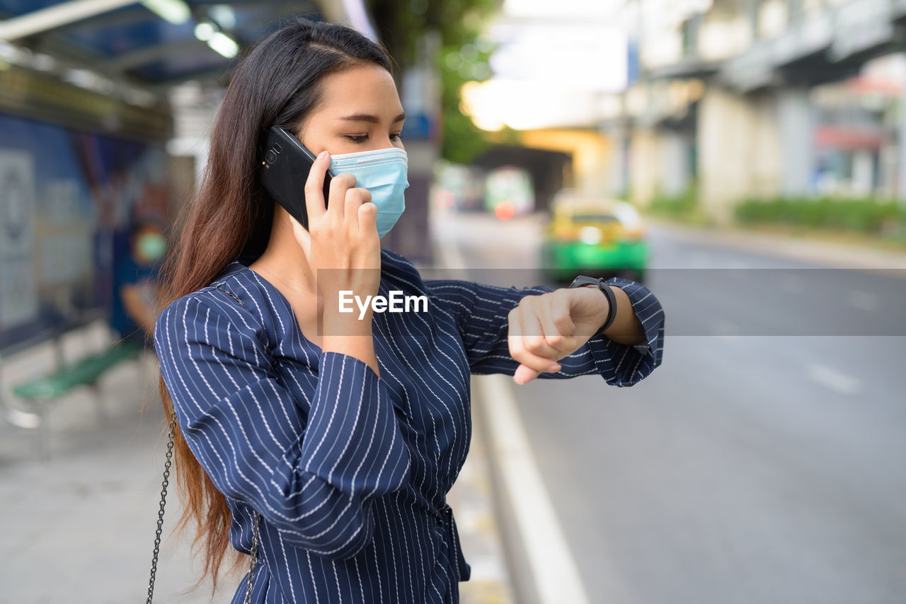 YOUNG WOMAN USING PHONE ON STREET