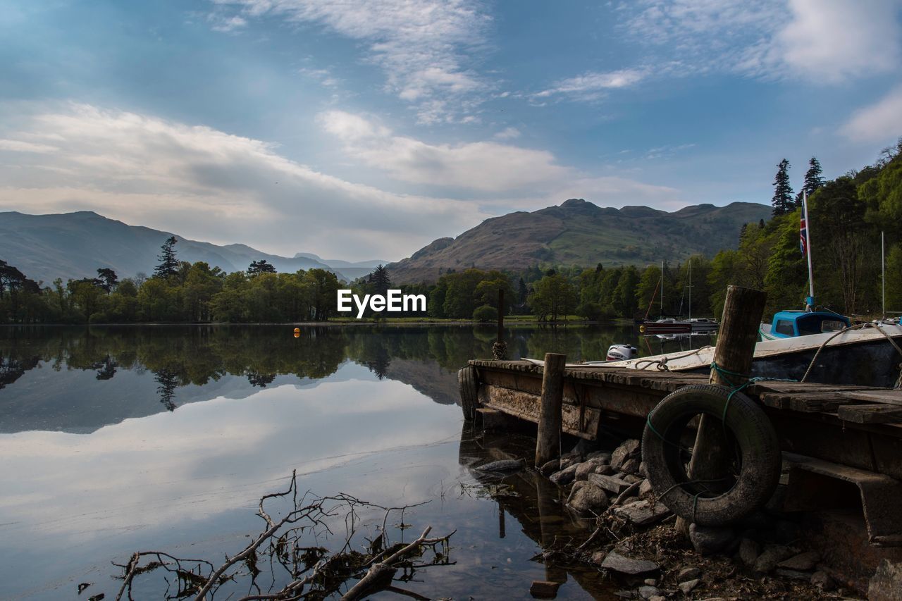 Scenic view of lake by mountains against sky
