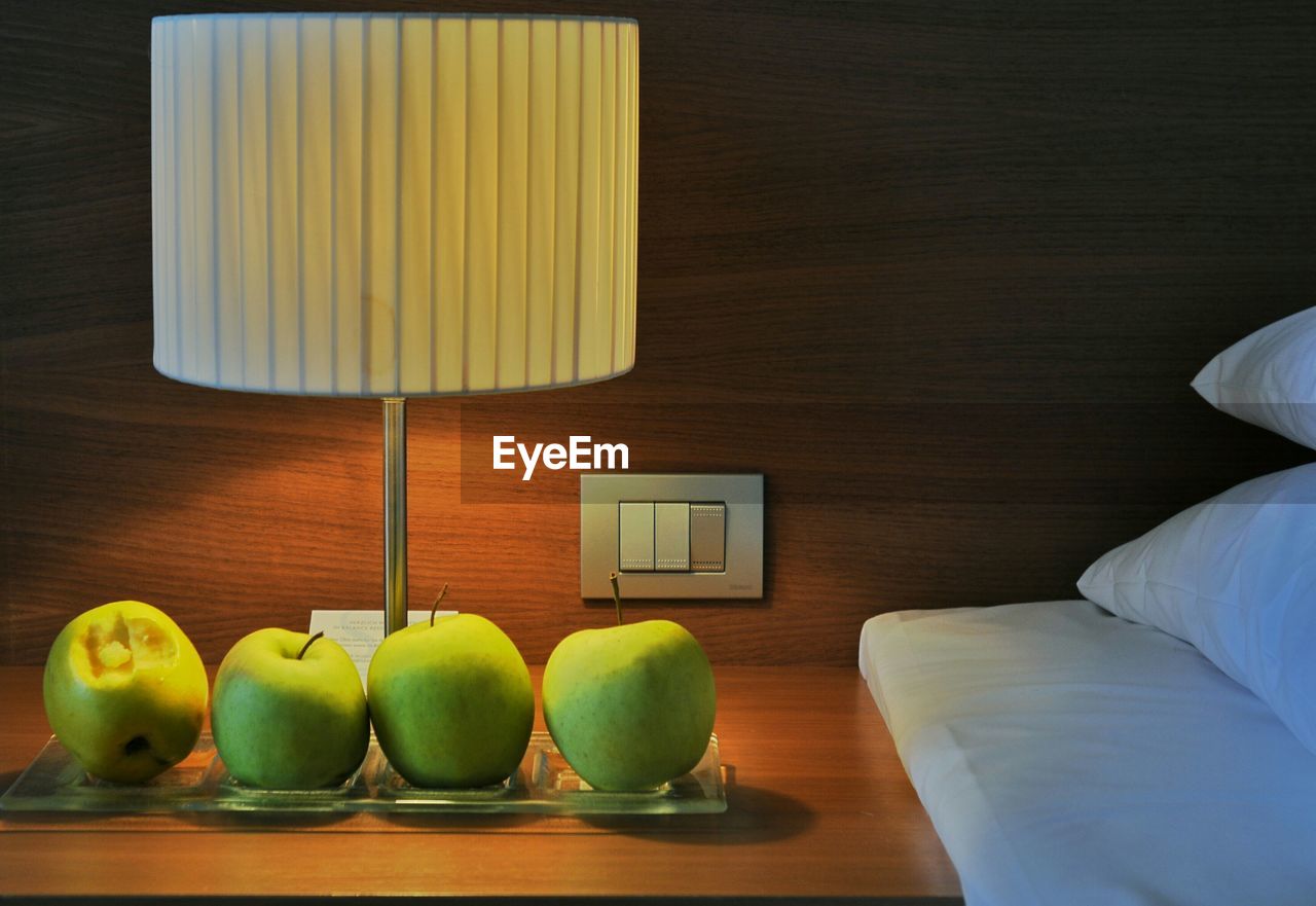 Green apples on a nightstand