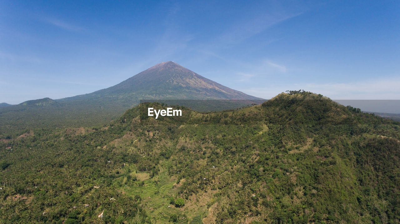 Aerial view of volcano mount agung with smoke billowing out at sunrise, bali, indonesia. 