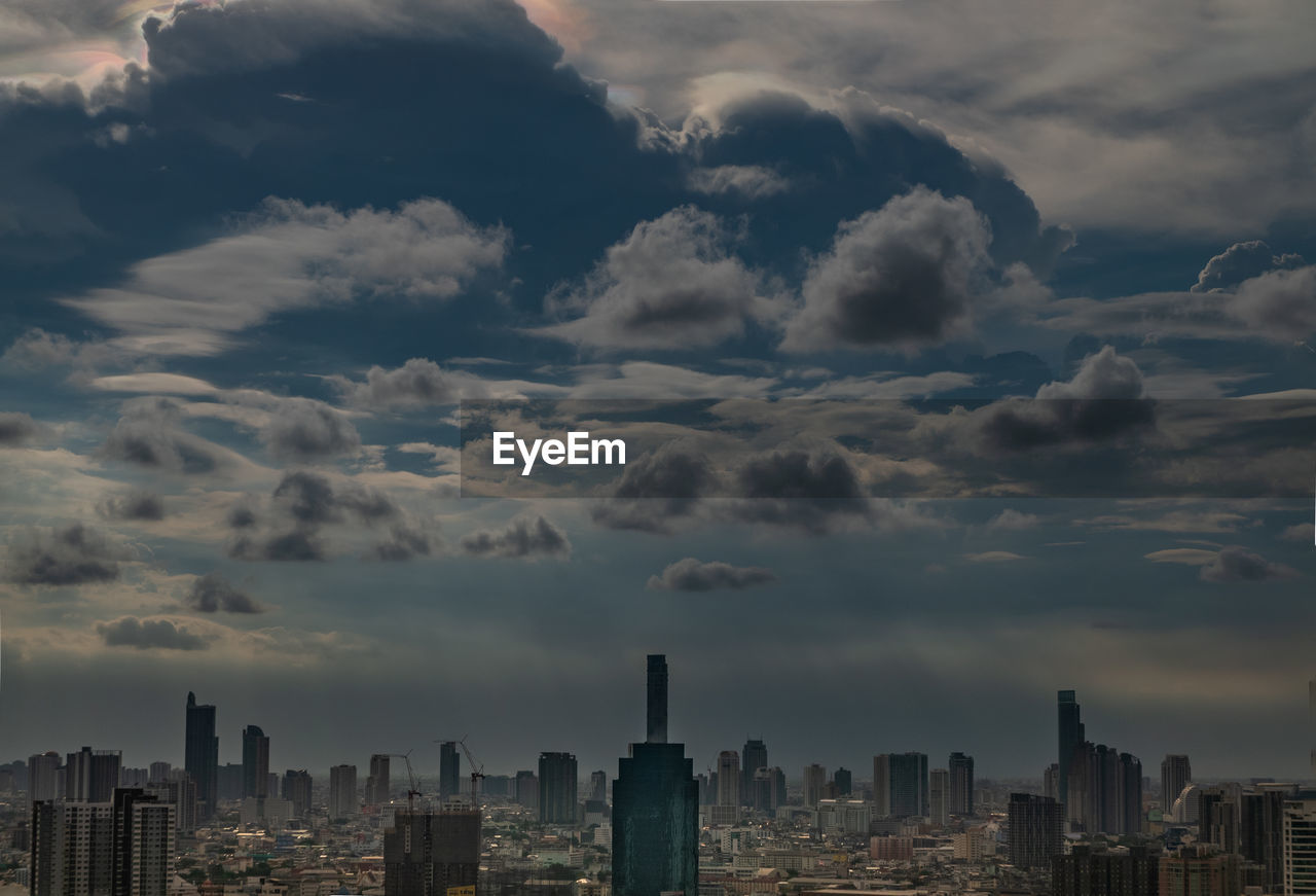 Aerial view of buildings in city against sky