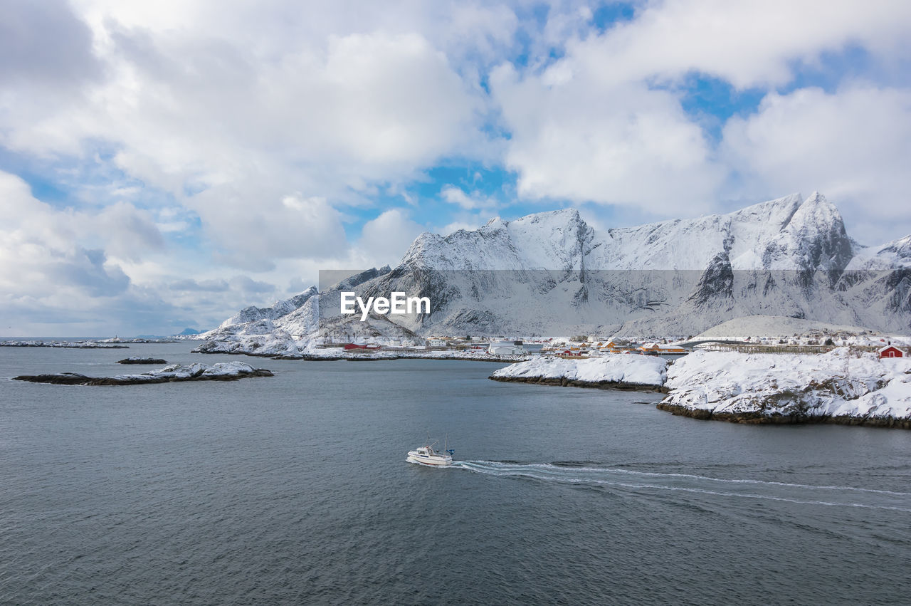 SCENIC VIEW OF SNOWCAPPED MOUNTAINS BY SEA AGAINST SKY