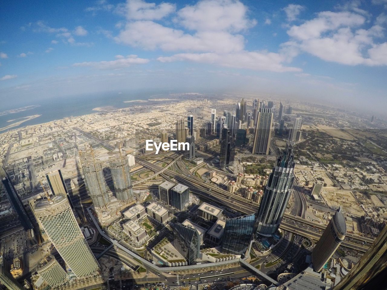 High angle view of dubai city buildings against cloudy sky