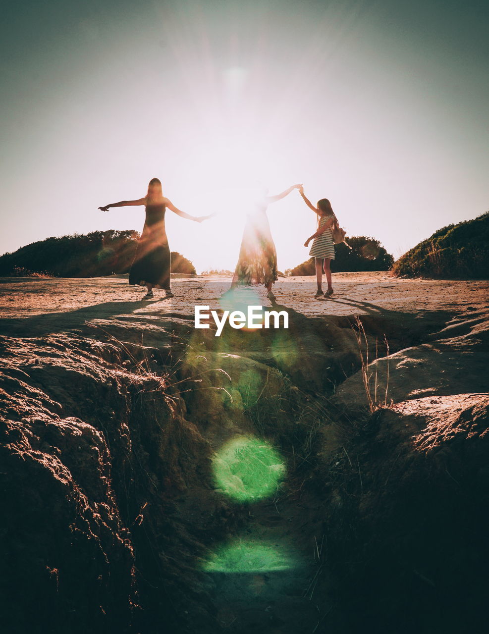 PEOPLE STANDING ON ROCKS BY LAND