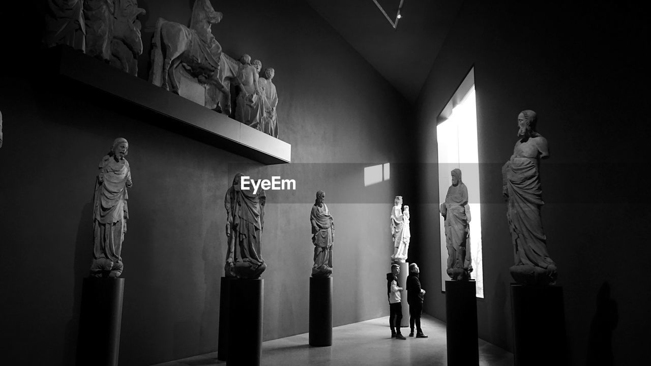 Men looking at sculptures in museum