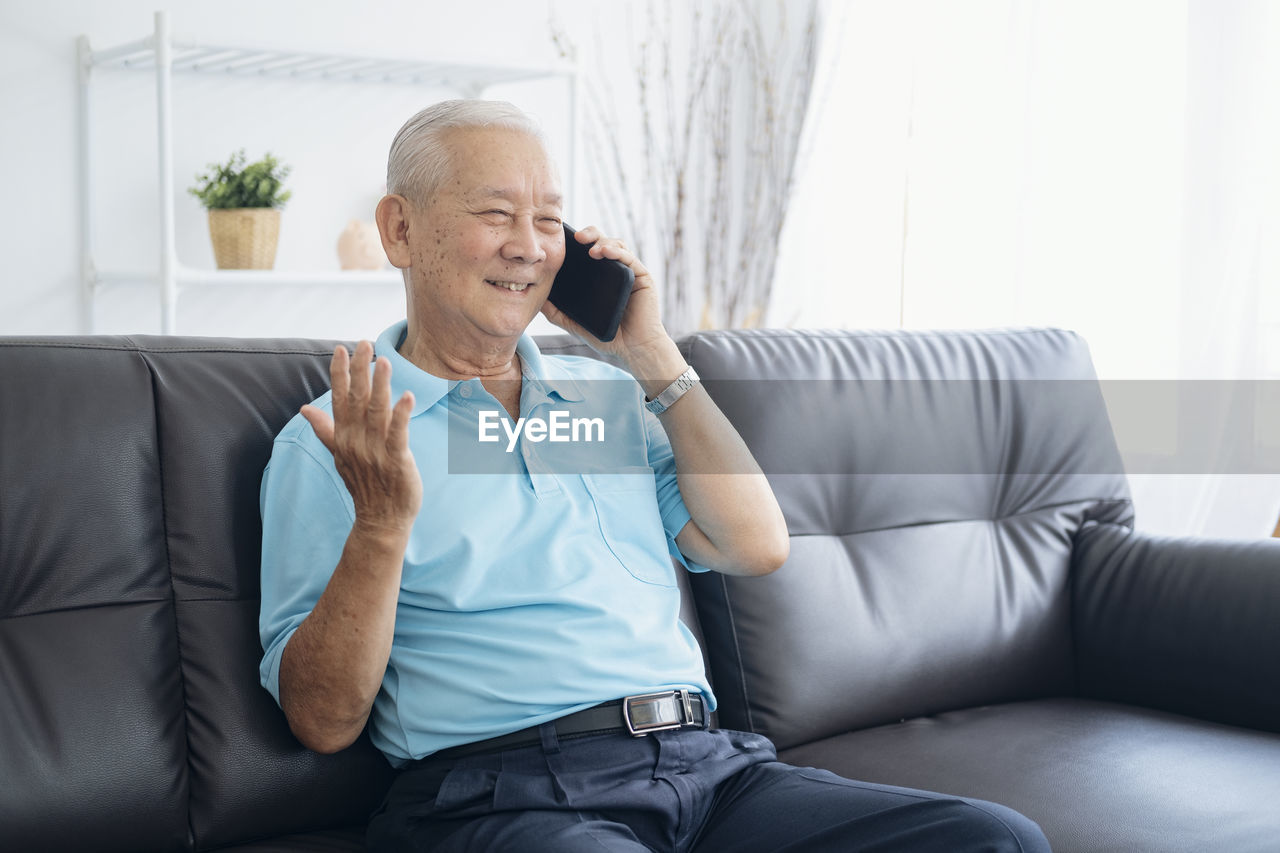 MAN SITTING ON SOFA