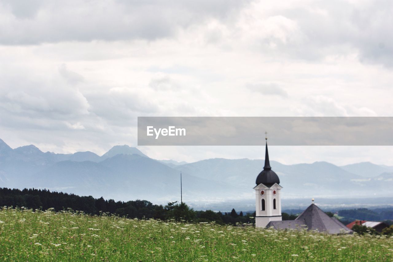 Church by mountains against sky