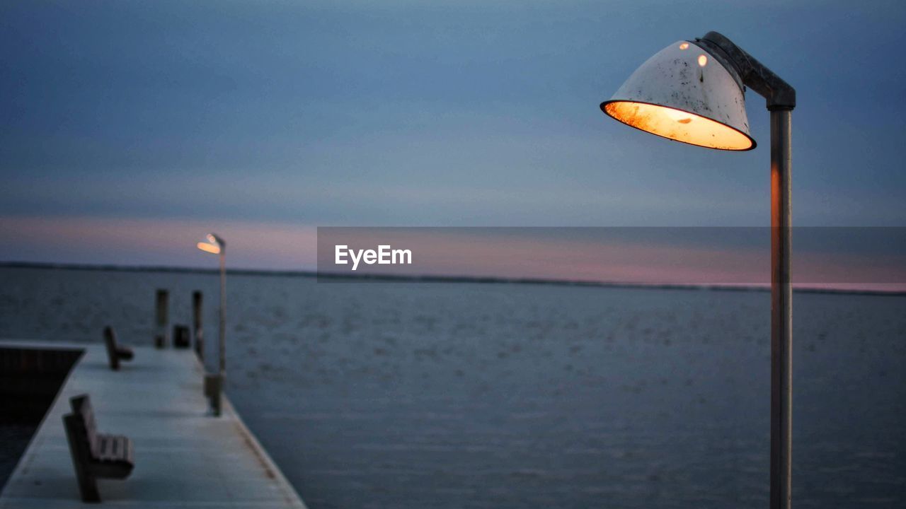 STREET LIGHT AGAINST SEA AT SUNSET