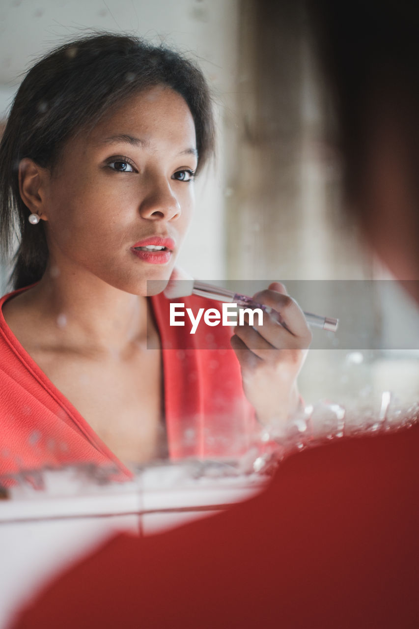 Portrait of young woman makeup in front of mirror