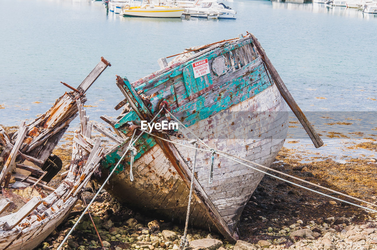 ABANDONED BOAT MOORED ON SHORE