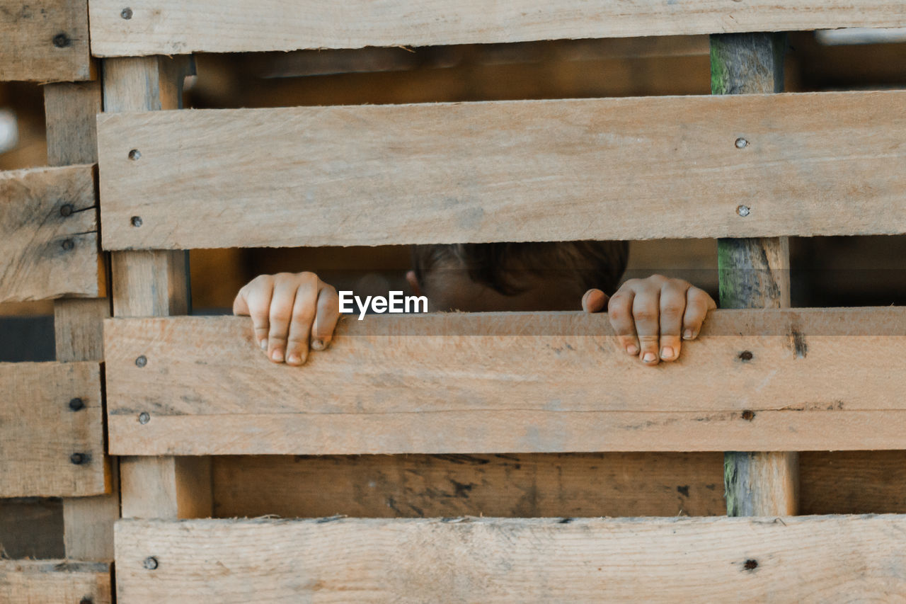 Boy seen through wooden fence
