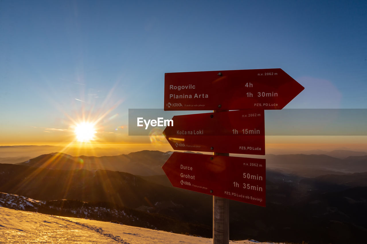 Information sign on mountain against sky during sunset