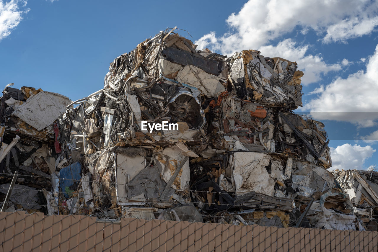 Low angle view of scarp garbage against sky