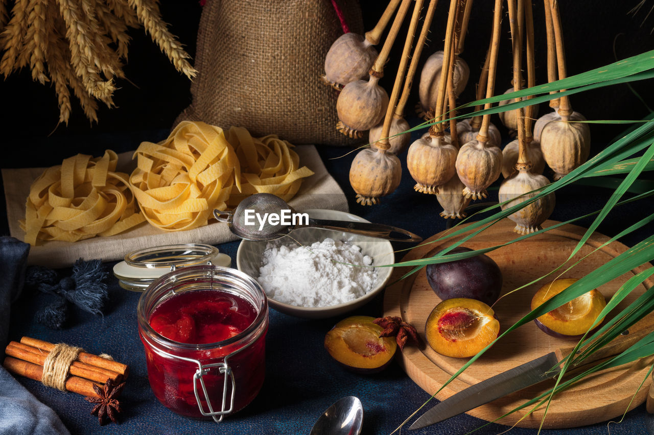 High angle close-up of sweet pasta dessert, noodles with poppy seeds on dark background table.