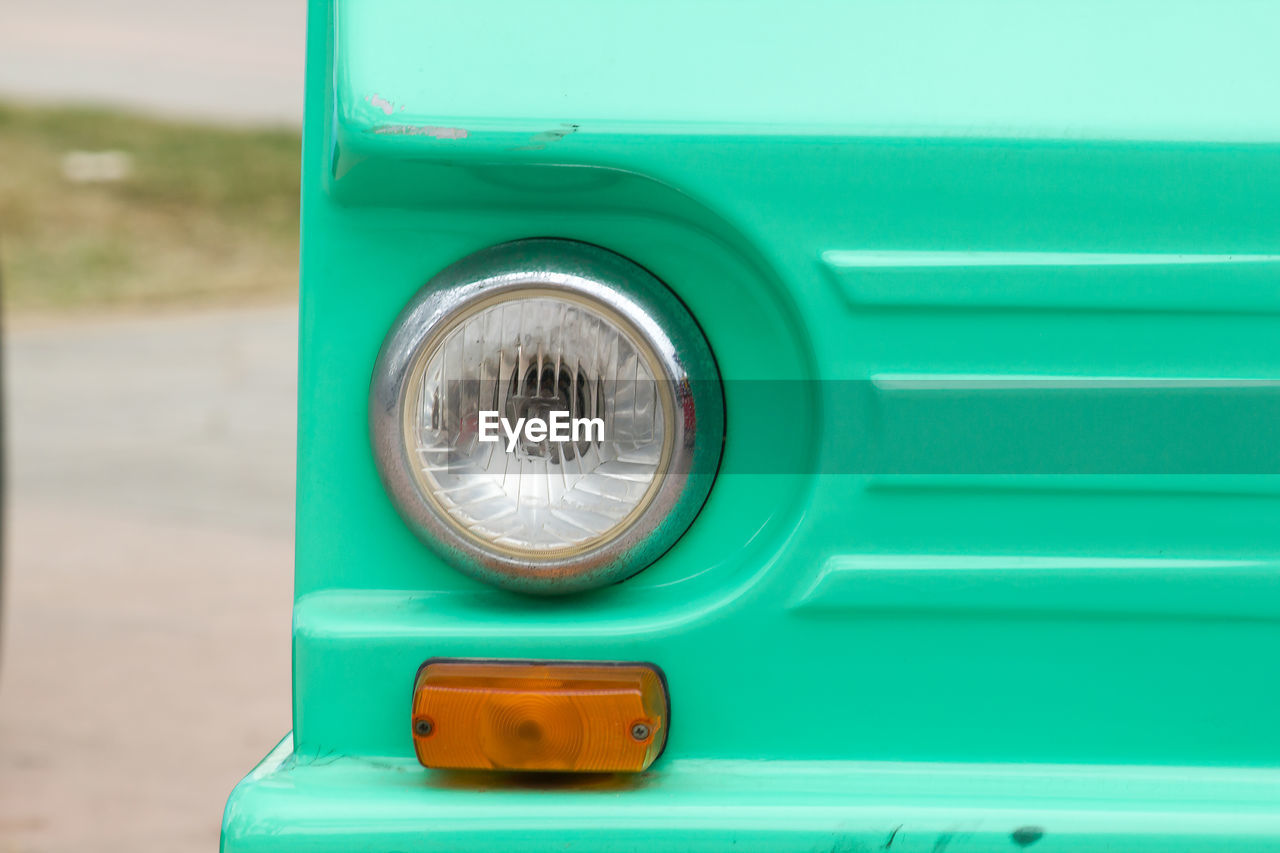 CLOSE-UP OF VINTAGE CAR ON BLUE CONTAINER