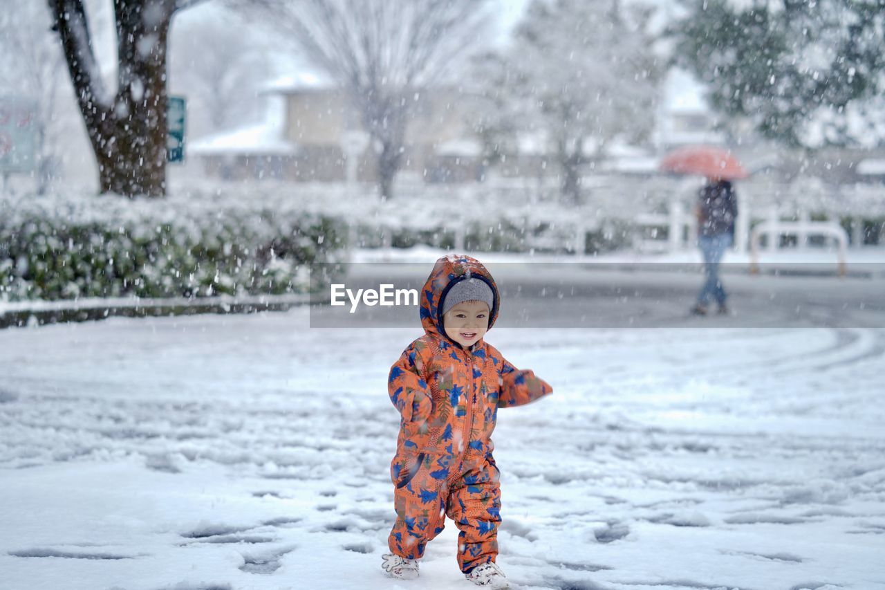 Full length of cute boy during winter. enjoy on snow floor in snowy day.
