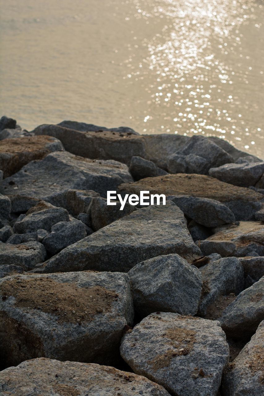 CLOSE-UP OF PEBBLES AT BEACH