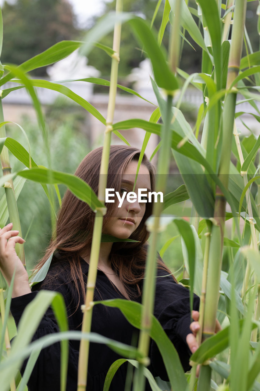 Portrait of woman with plants in field