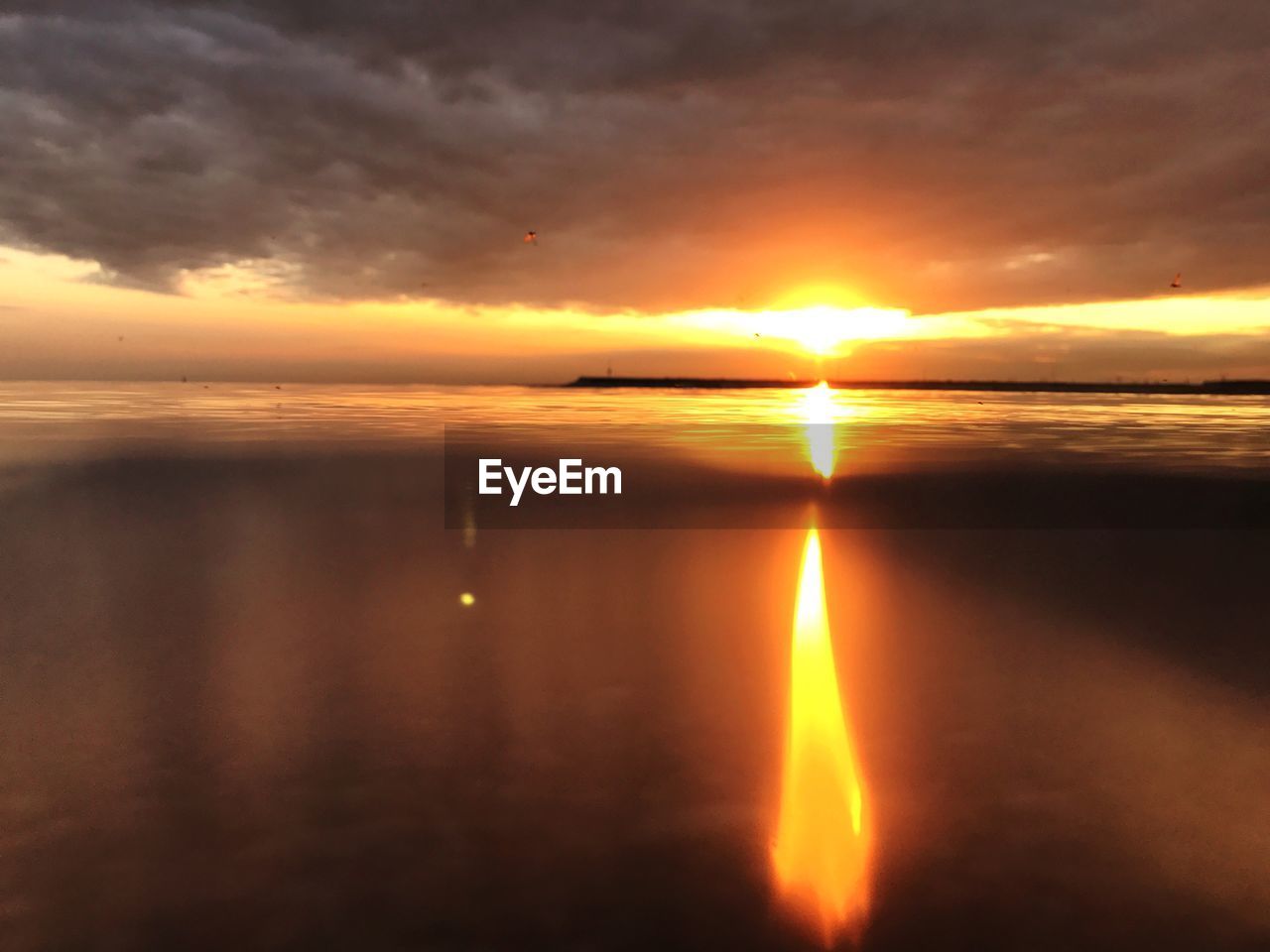 SCENIC VIEW OF SEA AGAINST ORANGE SKY DURING SUNSET