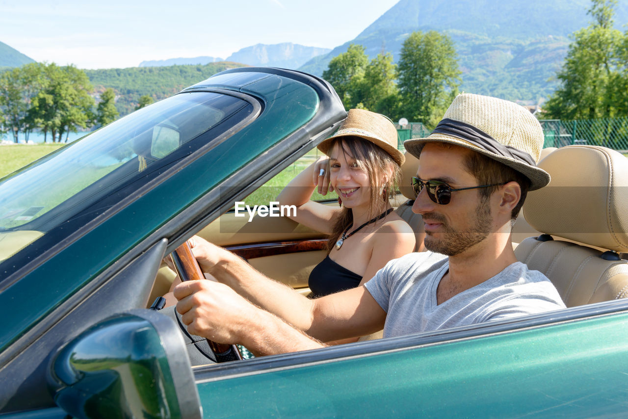 Couple traveling in convertible car