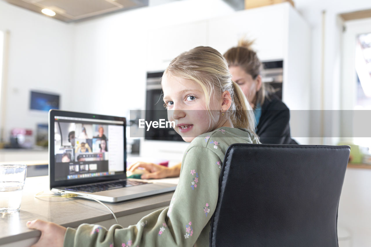 PORTRAIT OF SMILING YOUNG WOMAN USING LAPTOP