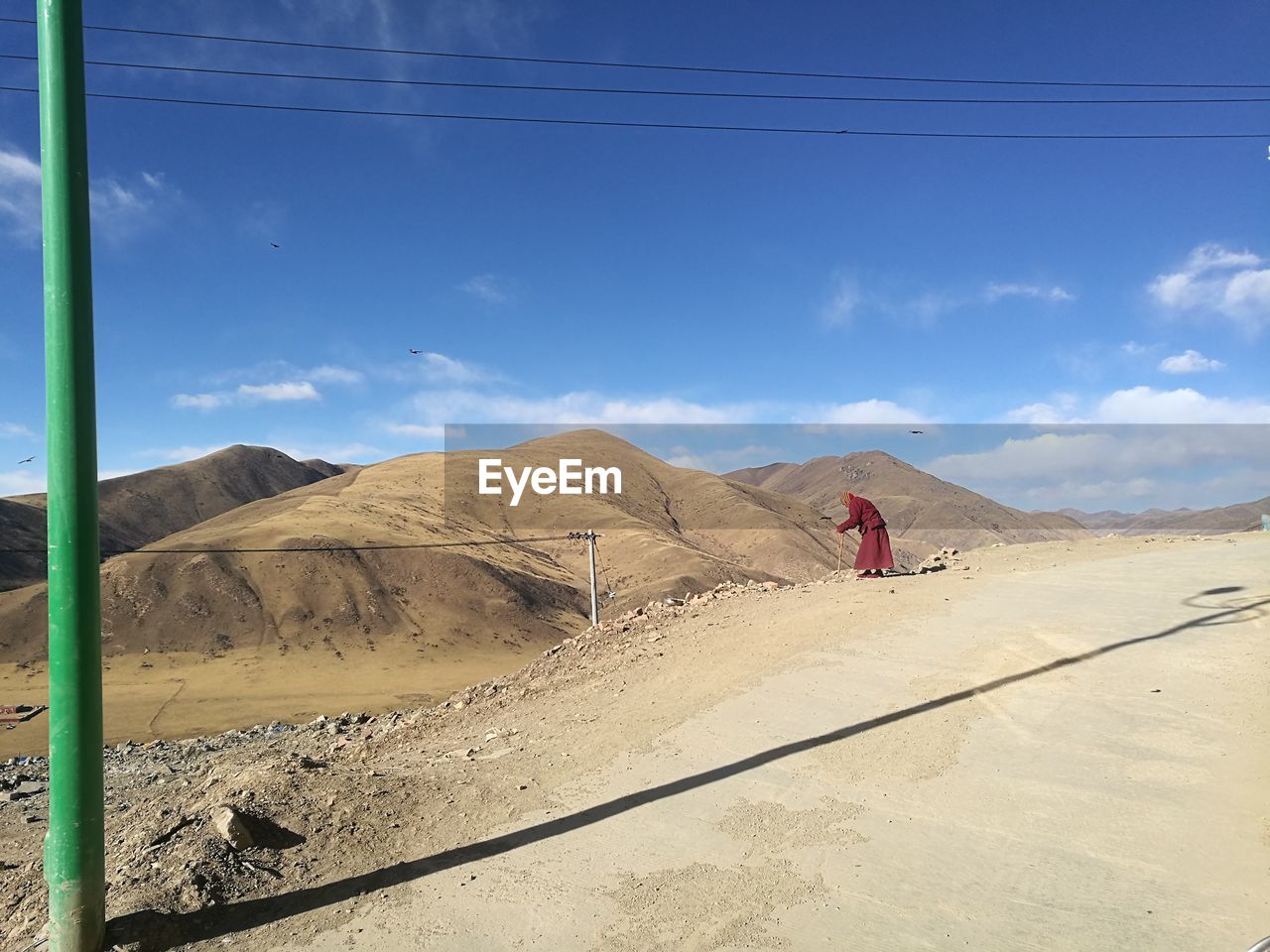 REAR VIEW OF MAN ON SAND DUNE IN DESERT