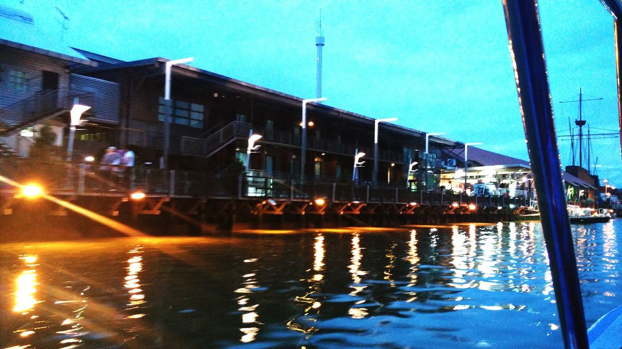 REFLECTION OF ILLUMINATED BUILDING IN WATER AT NIGHT