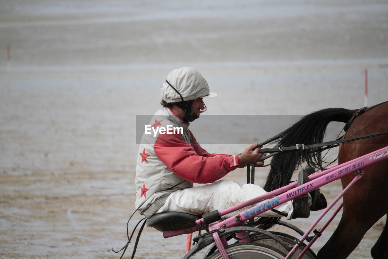 adult, one person, transportation, vehicle, side view, sitting, bicycle, water, sports, horse, day, nature, person, outdoors, activity, mode of transportation, men, focus on foreground, lifestyles, clothing, wheelchair