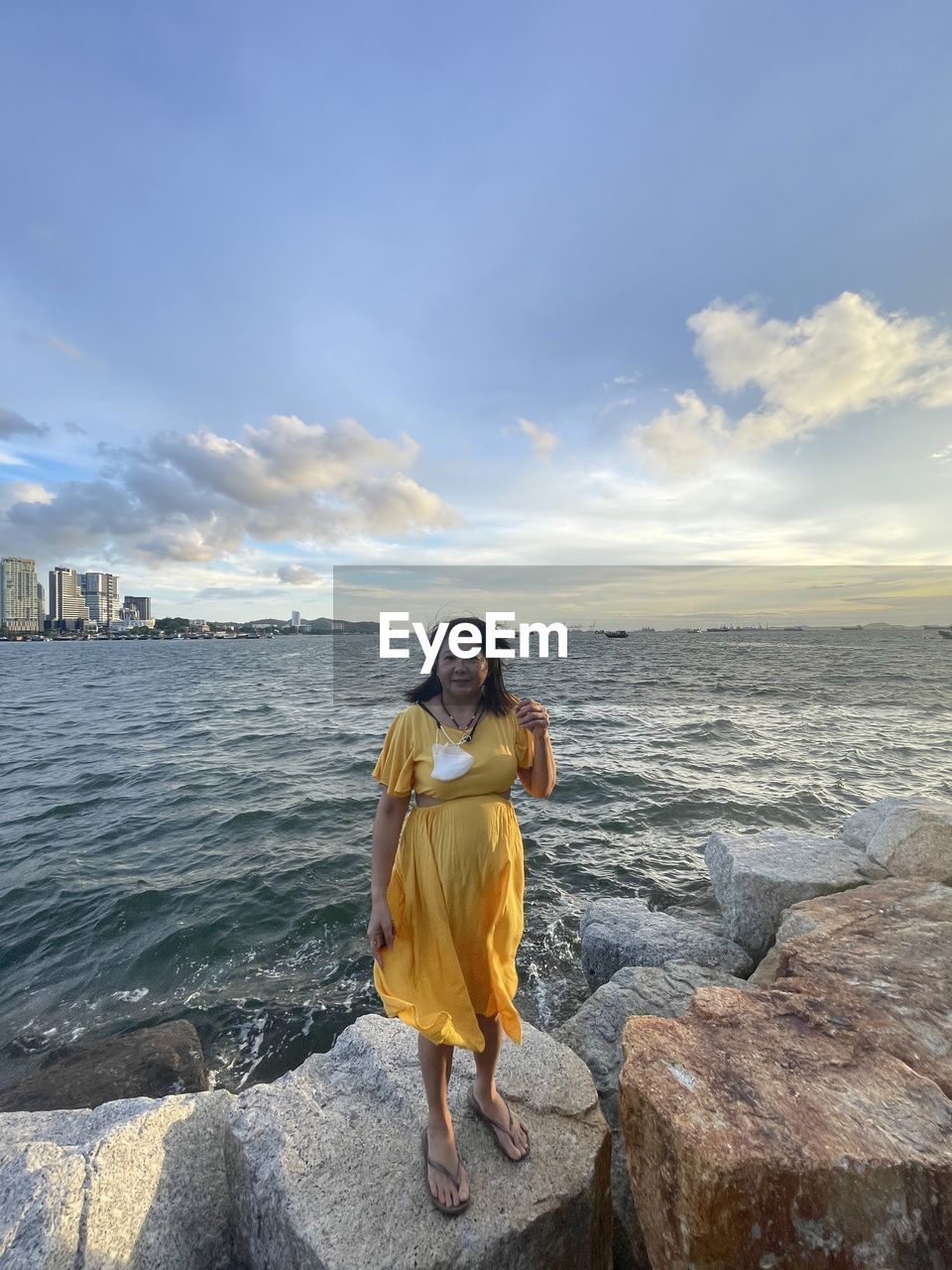 blue, nature, cloud, reflection, sky, yellow, day, water, outdoors, sunlight, one person, sports, extreme sports, motion, adventure, beauty in nature, rock, leisure activity, sea, full length, low angle view