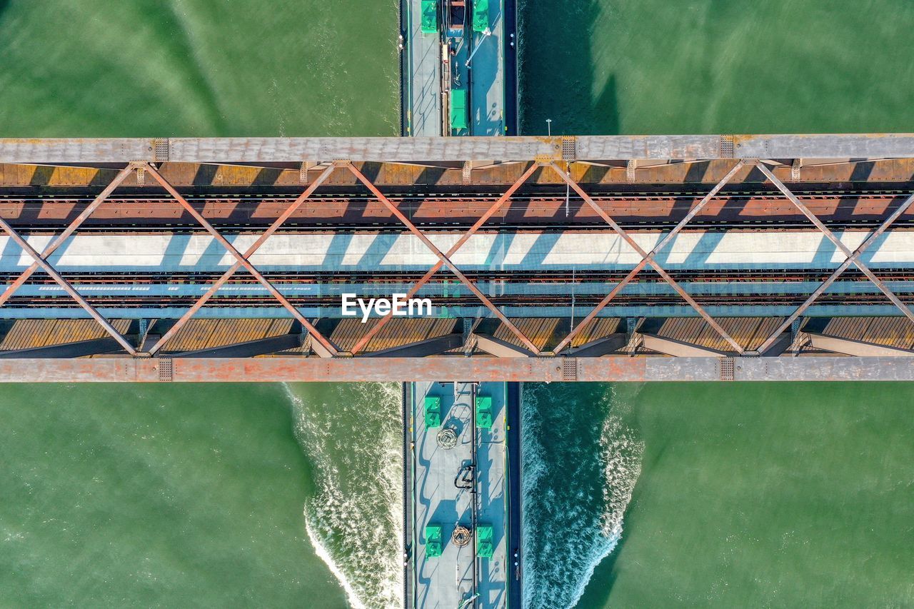 Aerial view of ship passing under bridge
