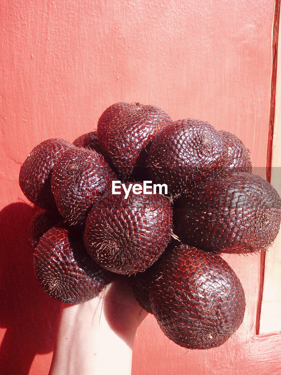 CLOSE-UP OF STRAWBERRIES ON TABLE AGAINST WALL