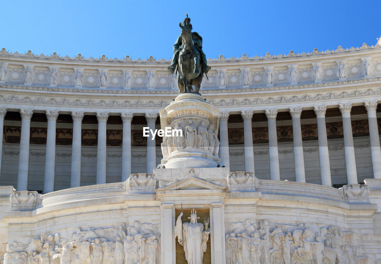 Low angle view of altare della patria against clear blue sky in city