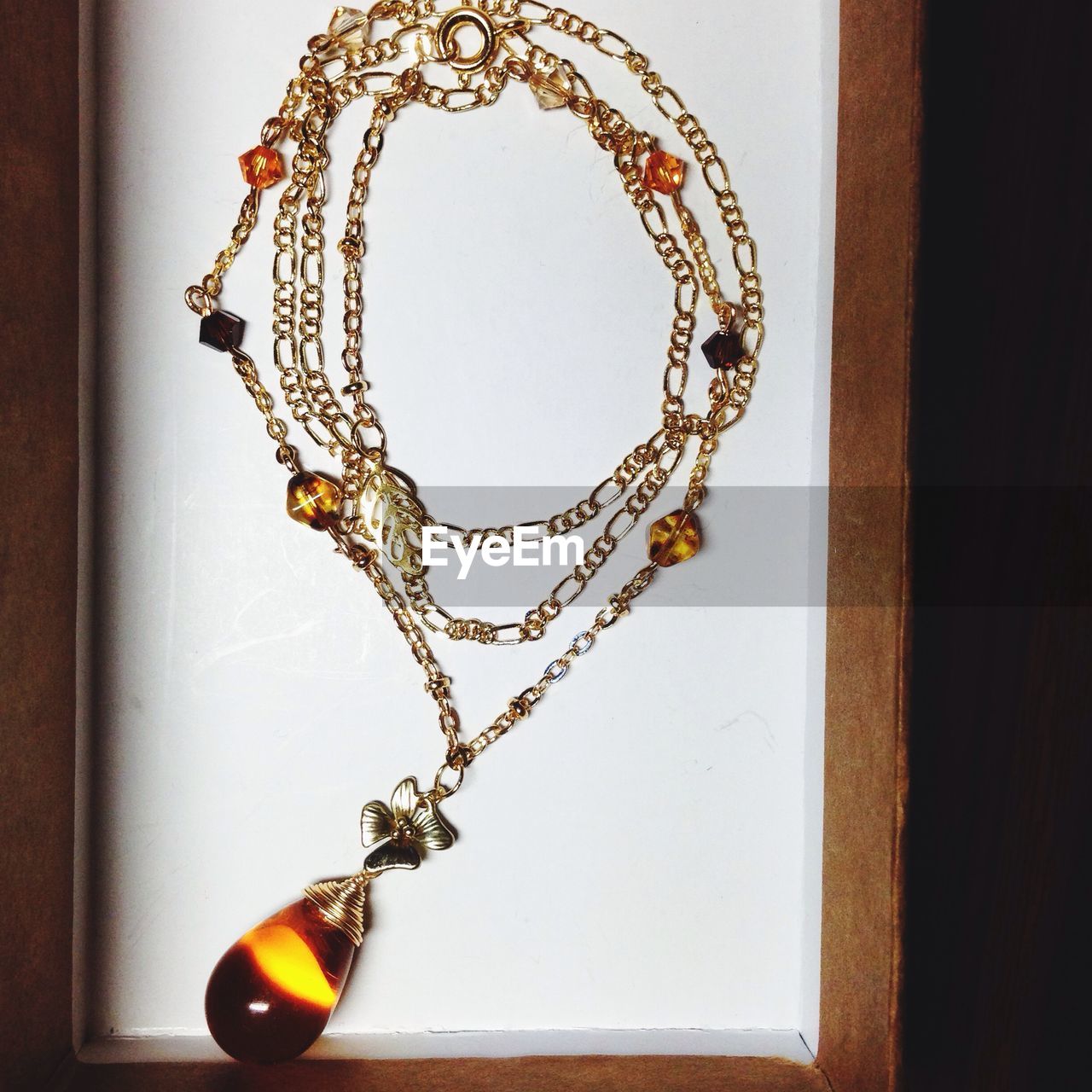 jewellery, necklace, fashion accessory, indoors, jewelry, no people, art, chain, hanging, close-up, yellow, gold, wood