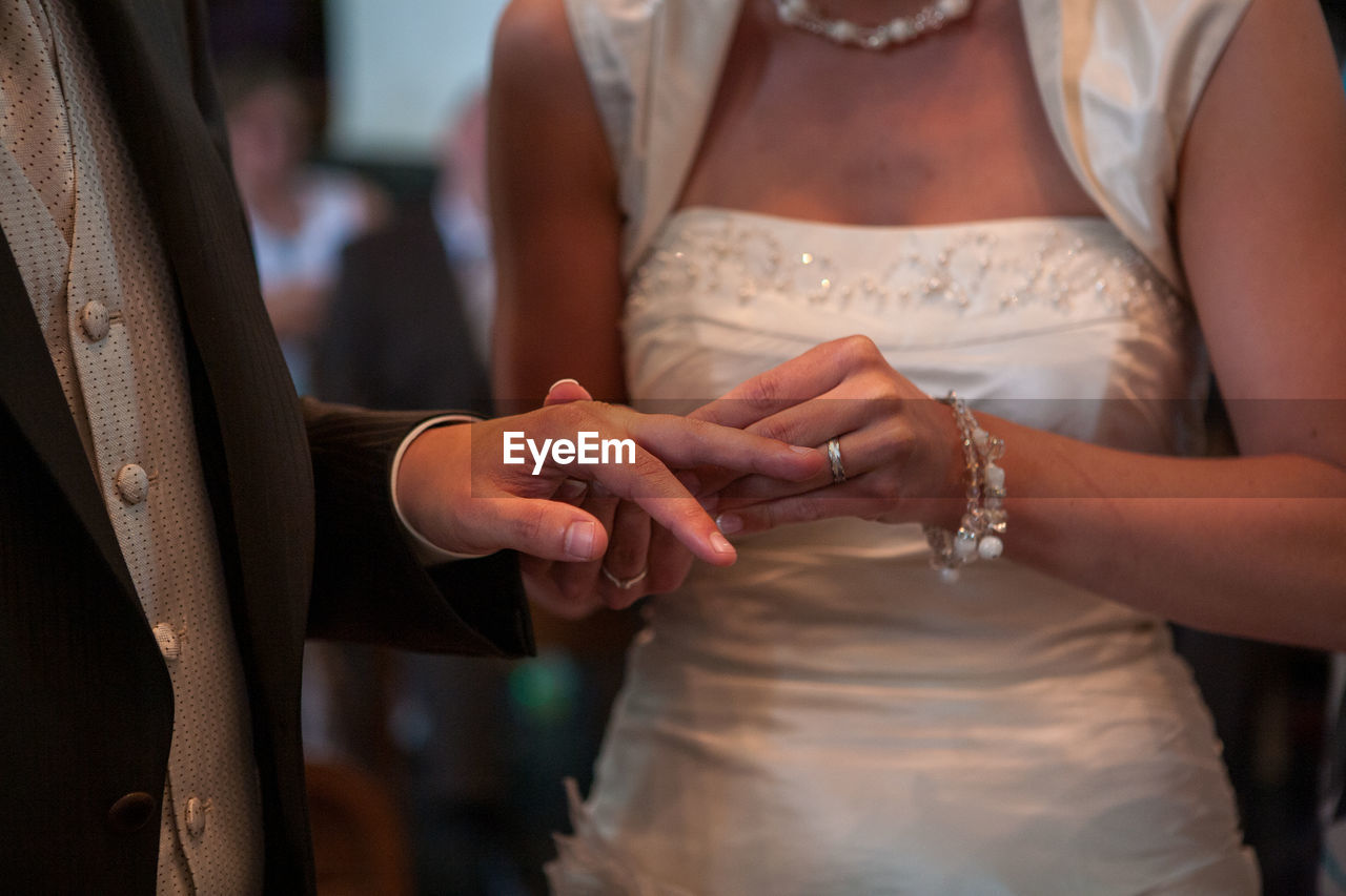 Midsection of couple holding hands