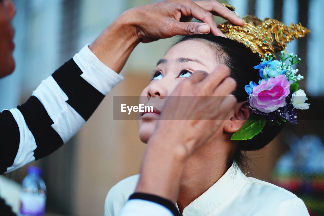 Artist applying make-up on young woman