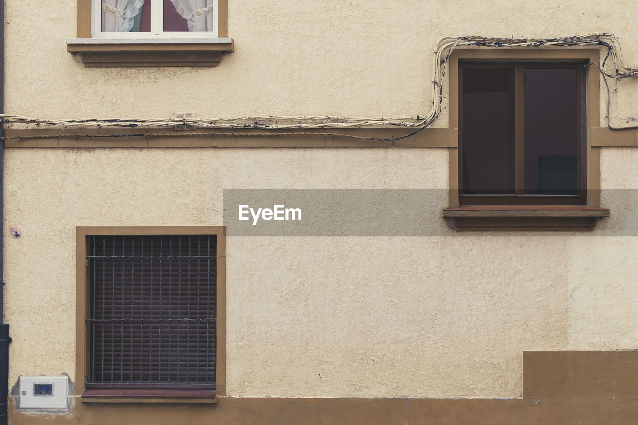 LOW ANGLE VIEW OF WINDOW ON HOUSE WALL