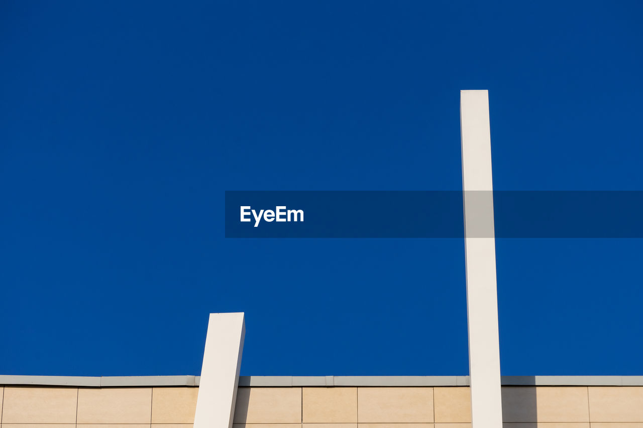 Abstract architectural detail of a modern office building facade isolated with blue sky background.