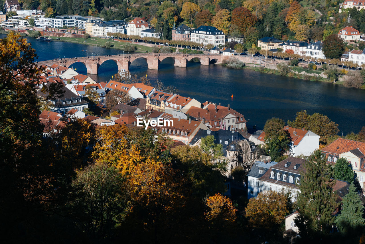 HIGH ANGLE VIEW OF TOWNSCAPE BY RIVER AGAINST BUILDINGS