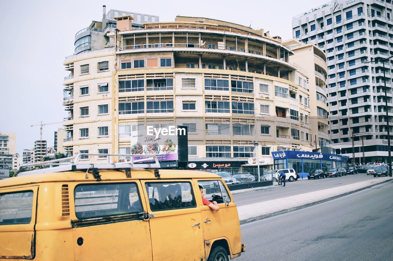 VEHICLES ON STREET AGAINST SKY