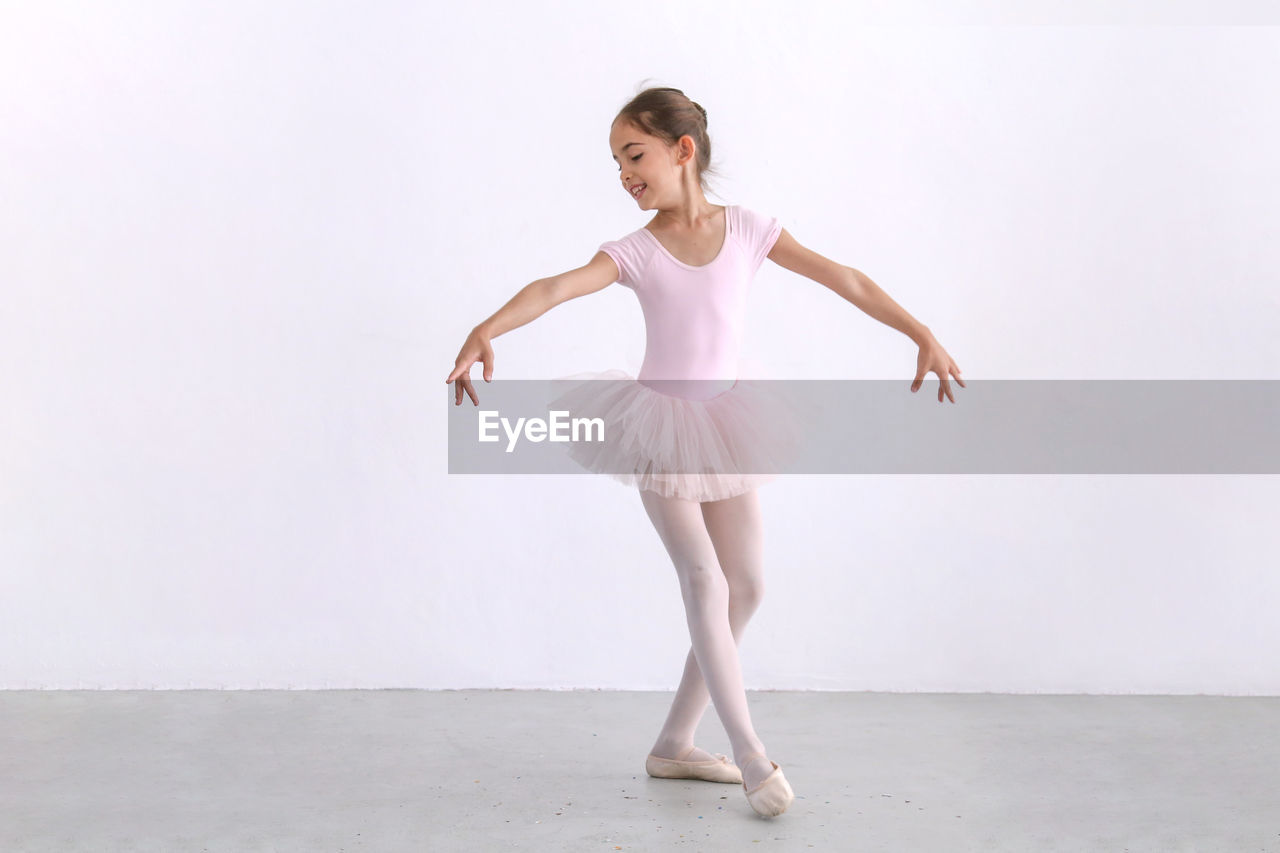 Full length of girl ballet dancing against white background