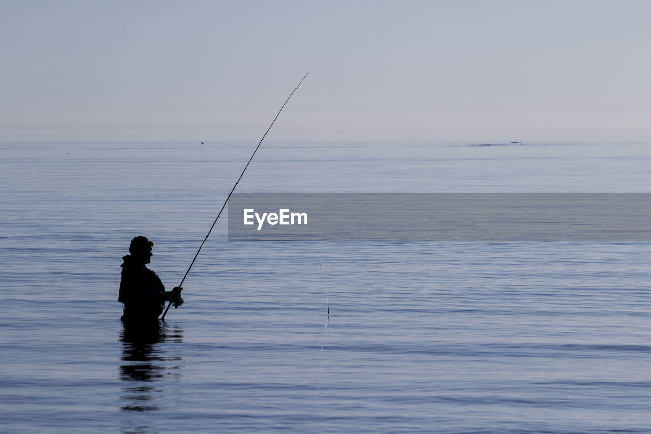 MAN FISHING IN SEA