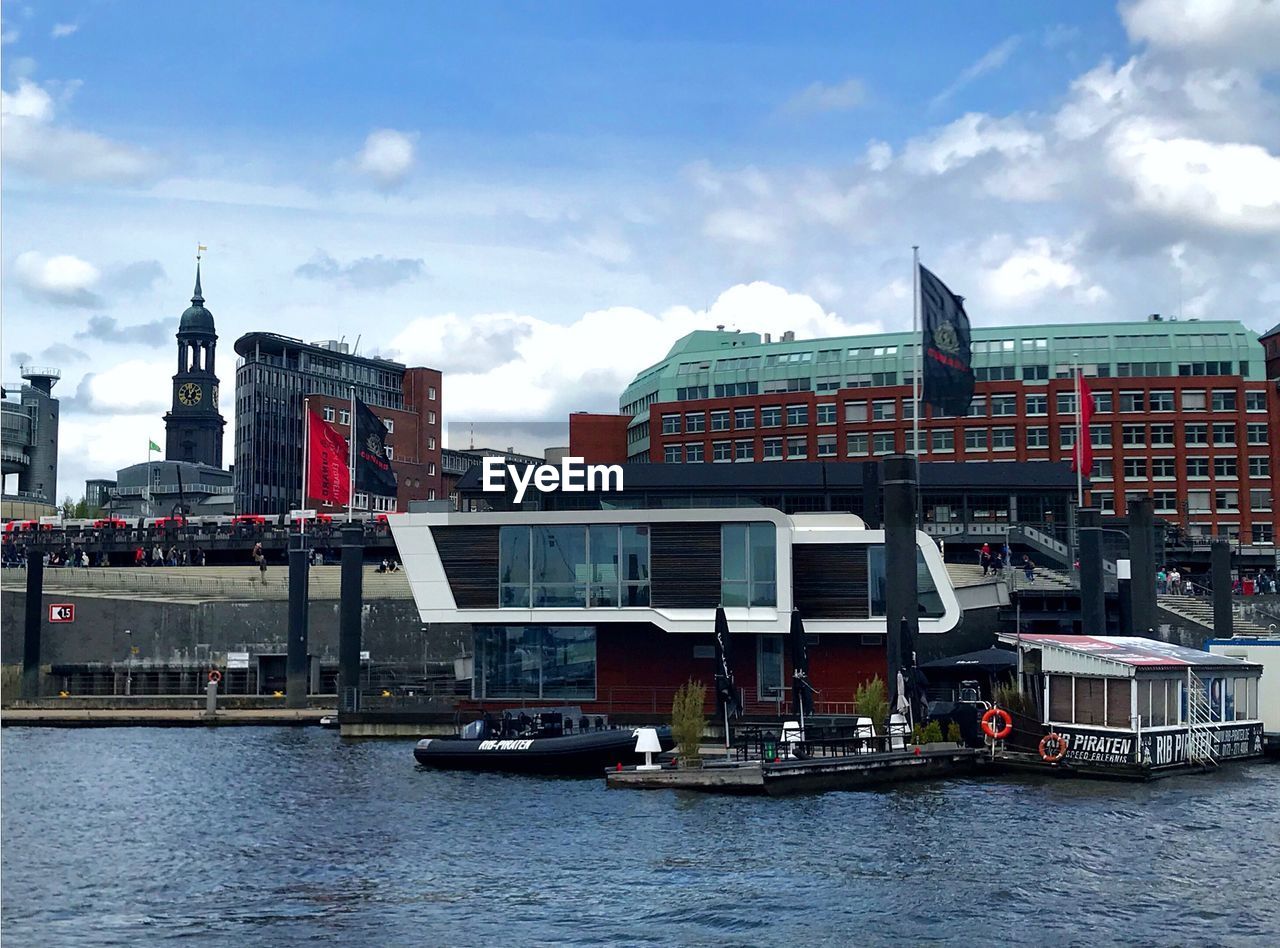 BOATS IN RIVER AGAINST BUILDINGS