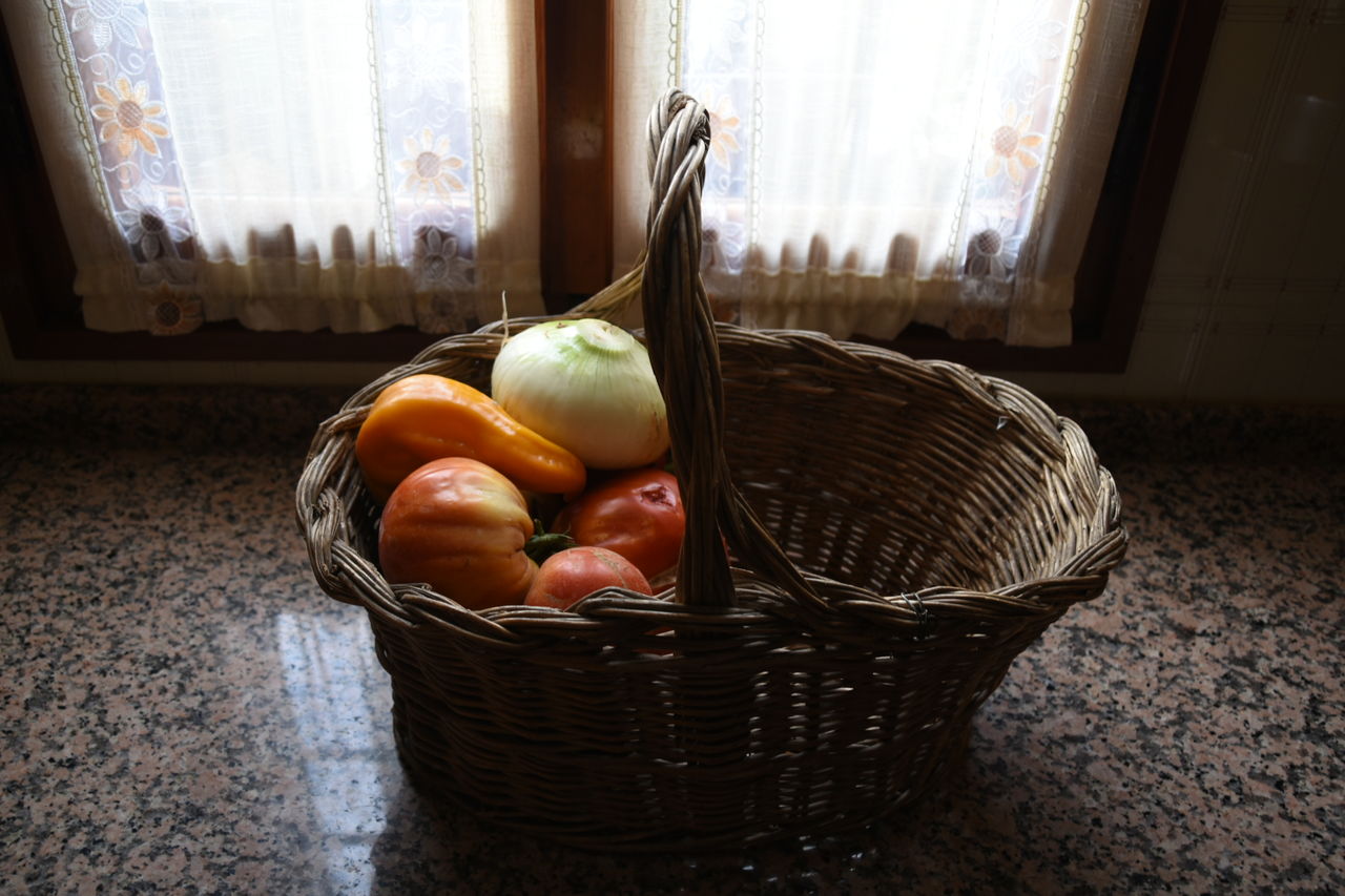 Close-up of onion and bell peppers in basket on kitchen counter