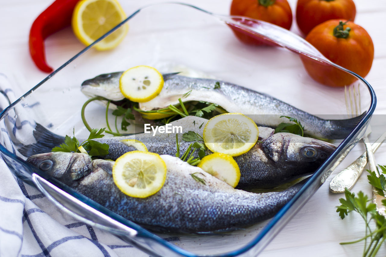 HIGH ANGLE VIEW OF FISH IN CONTAINER ON TABLE